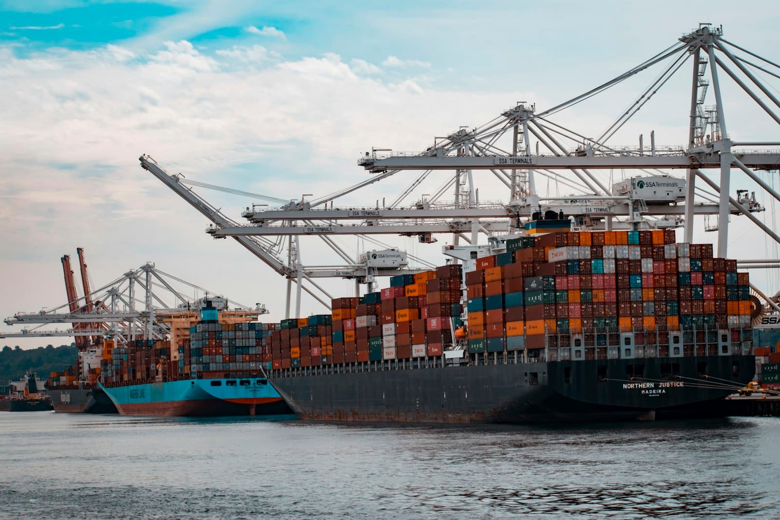 Container ship alongside cranes at a commercial port